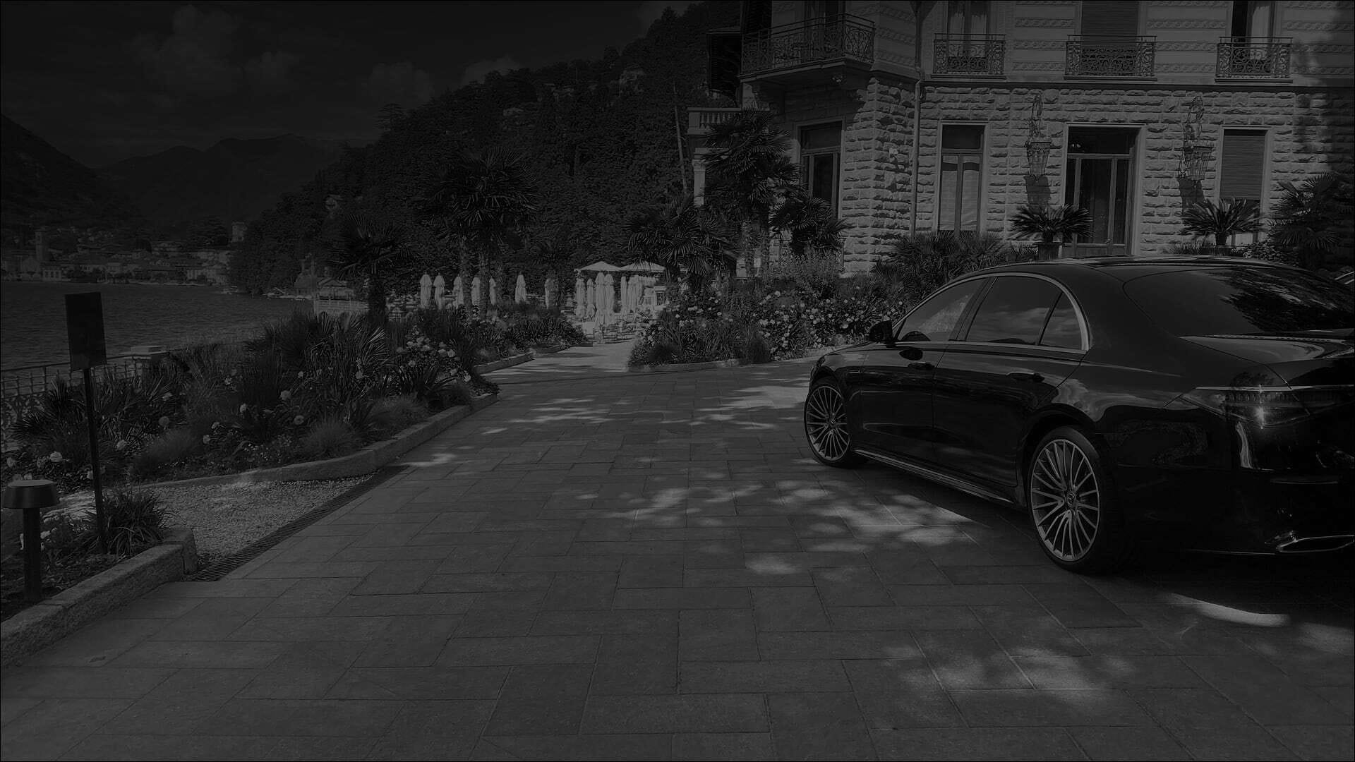 foto di macchina mercedes nera parcheggiata in un cortile di una villa