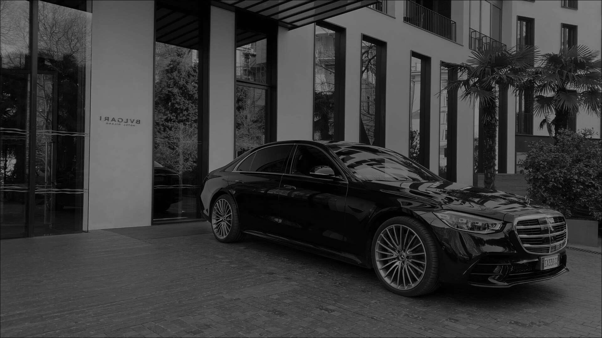 foto di macchina mercedes nera parcheggiata davanti a un edificio moderno